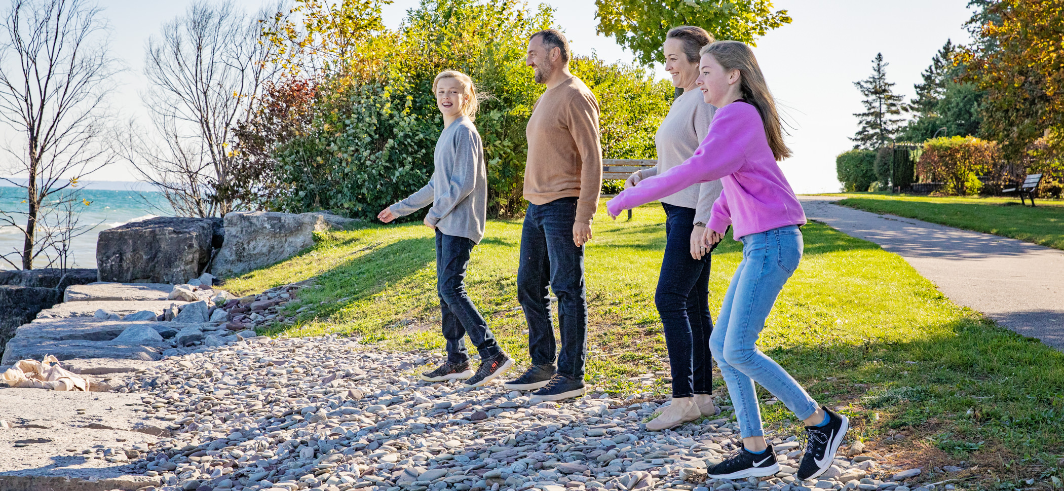 Family skipping rocks on oakville lakefront