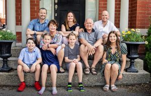 extended family sitting on front steps of home in fathers day photo session