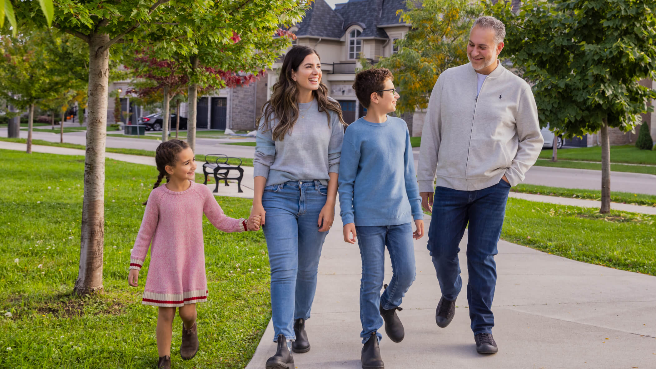 family laughing and walking on sidewalk