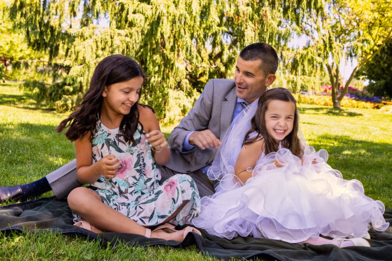 dad laughing with two daughters